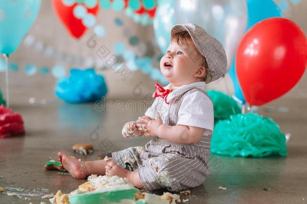 凌乱的婴儿男孩吃蛋糕向他的1SaoTomePrincipe圣多美和普林西比生日有样子的在上面