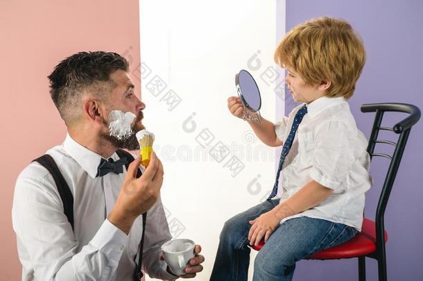 理发店.时髦的和时髦的父亲和儿子.理发师剃胡子一
