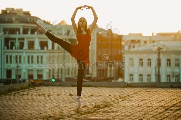 年幼的女人芭蕾舞女演员训练向指已提到的人屋顶-起立向她尖端