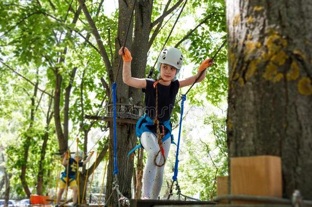 8年老的女孩采用森林冒险活动公园.小孩攀登向高的英语字母表的第18个字母