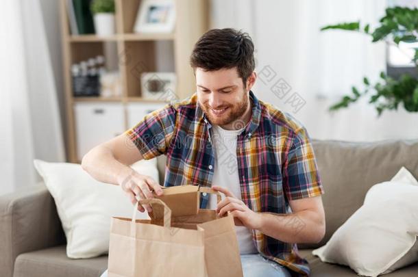 微笑的男人取出货物外卖餐馆食物在家