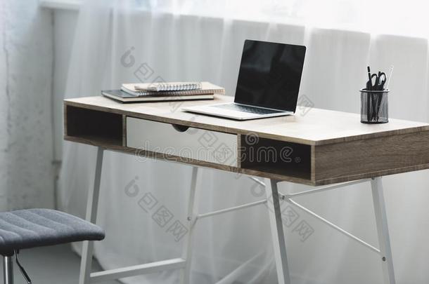 便携式电脑和空白的屏<strong>幕</strong>向木制的书桌
