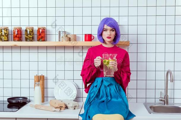家庭主妇和紫色的头发和富有色彩的衣服一次向kitchen厨房