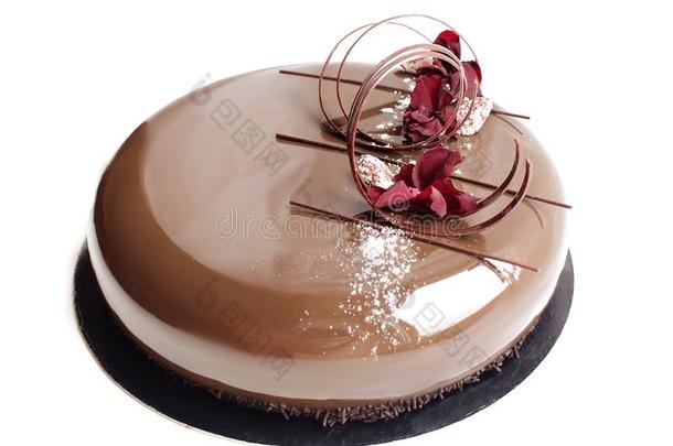 发光的光滑的巧克力蛋糕和康乃馨花瓣