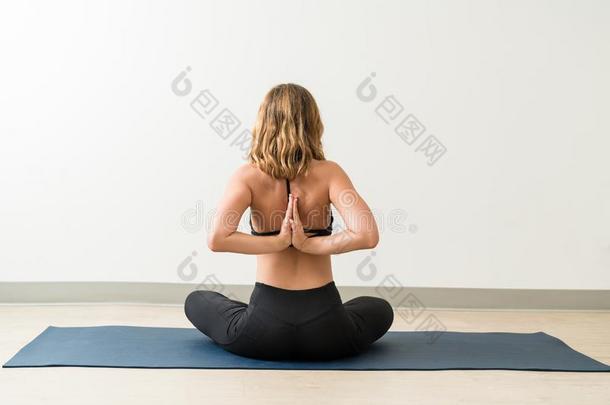 年幼的女士开业的瑜珈的任何一种姿势采用前面关于墙