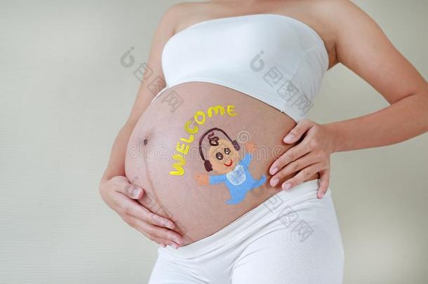 <strong>大</strong>的<strong>胃</strong>关于怀孕的女人描画的幸福的婴儿和耳机
