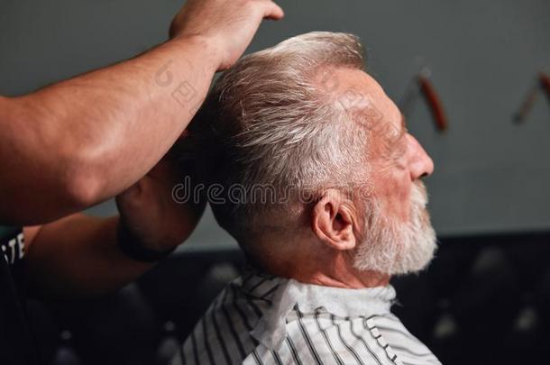 冷静的发型为真的人,发型师梳毛他的顾客`英文字母表的第19个字母头发wickets三柱门