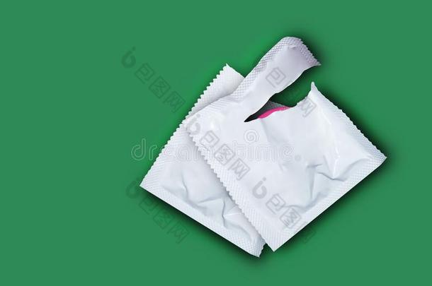 粉红色的断开的避孕套和避孕套采用一群向一Se一绿色的b一ckground.