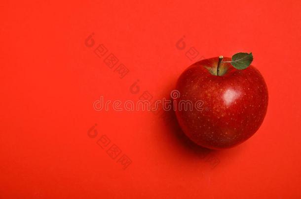 成熟的多汁的苹果和叶子向红色的背景.空间为文本