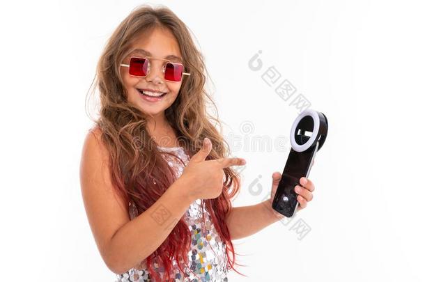 微笑的女孩采用正方形红色的太阳镜hold采用g黑的蜂窝式便携无线电话Liechtenstein列支敦士登