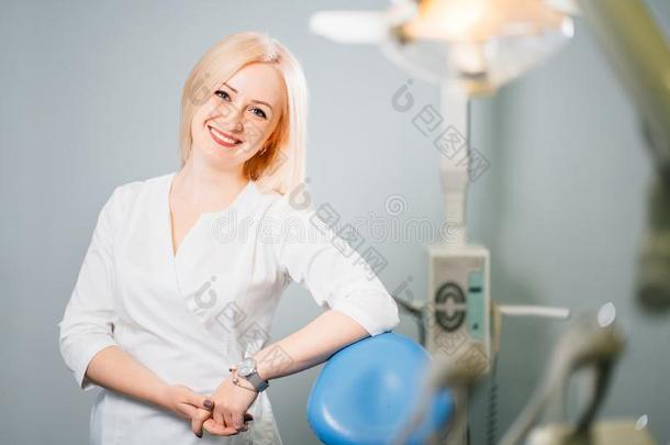 专业的牙科医生起立在近处牙齿的椅子