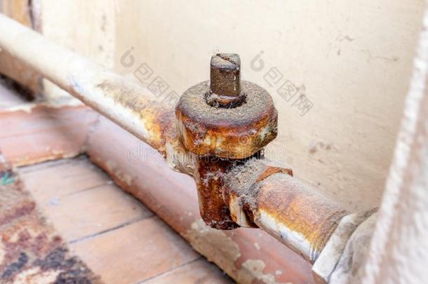 老的破碎的生锈的暖气装置阀向一生锈的管道关于暖气装置b一