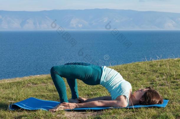 生活方式观念-年幼的女人制造瑜伽练习向海滩