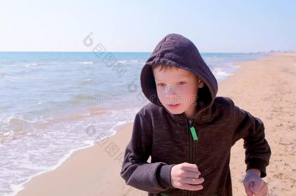 小孩男孩是（be的三单形式慢跑步行向海沙海滩小的赛跑者向