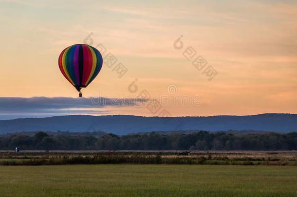 彩虹热的-天空气球彩车越过田在日出