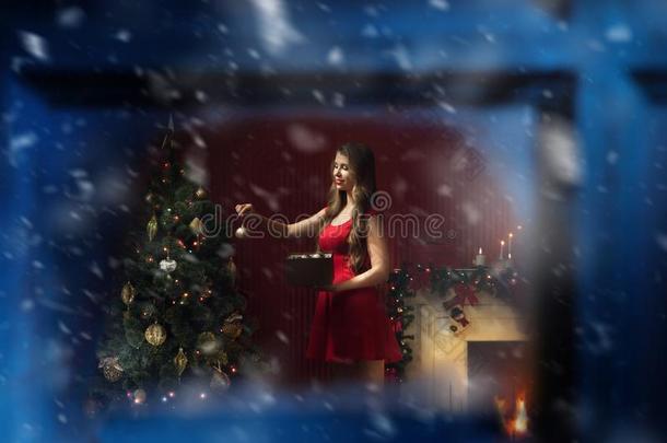 美好的女人采用红色的衣服decorat采用g圣诞节树