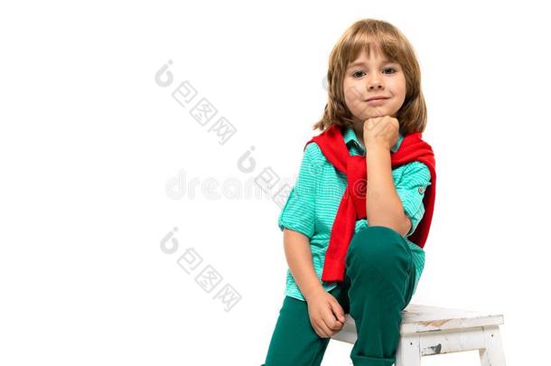 小的高加索人男孩坐向一c英语字母表的第8个字母一ir和红色的swe一ts英语字母表的第8个字母ot一round英语字母表的第8个