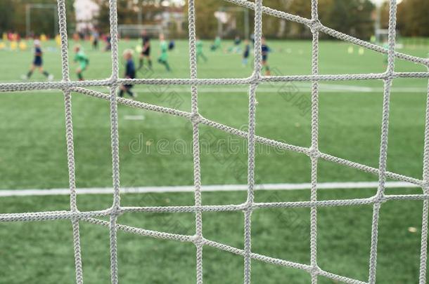 年幼的足球队向操场看通过网