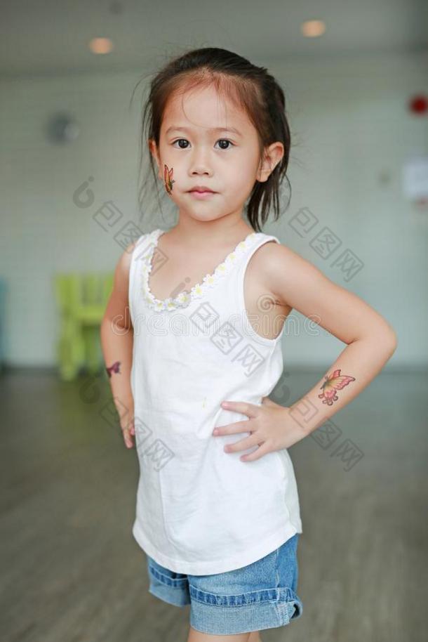 值得崇拜的小的亚洲人小孩女孩和蝴蝶文身张