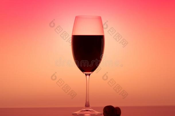 不光滑的葡萄酒杯一半的红色的葡萄酒桔子背景软木向表