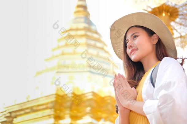 女人旅行支票旅行者祈祷在佛教的庙.旅行旅游