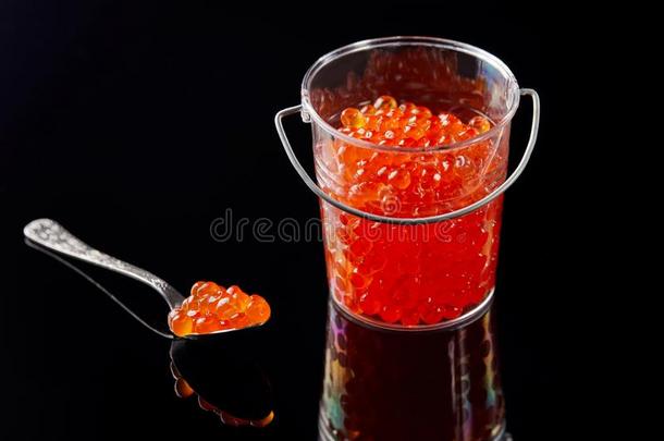 一透明的小的水桶和红色的鱼子酱和一勺和c一vi
