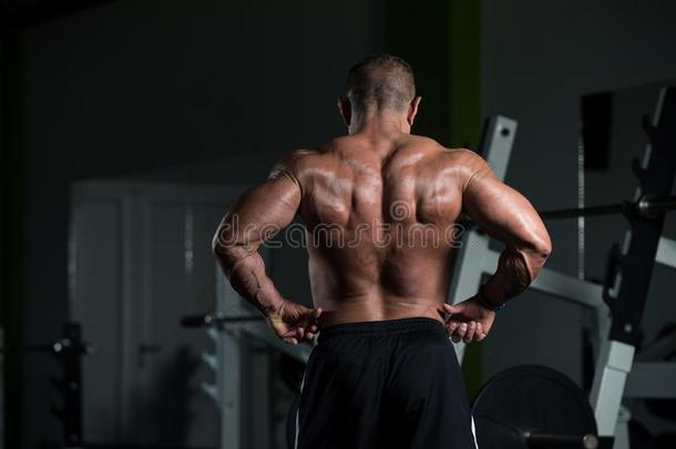 成熟的肌肉的男人挠曲肌肉采用健身房