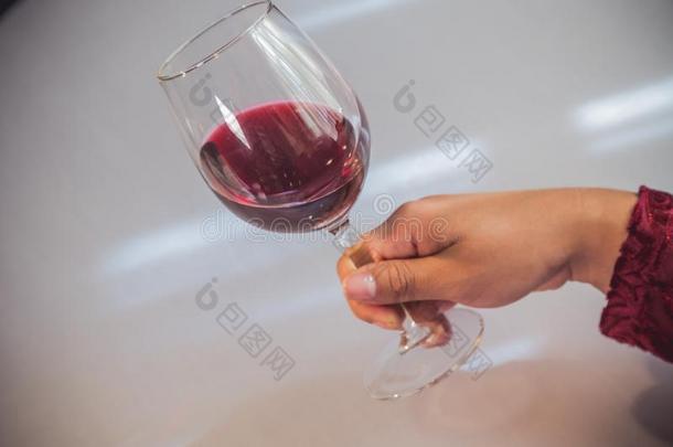 玻璃关于红色的葡萄<strong>酒</strong>拿在旁边一wom一n&字母x27;英文字母表的第19个字母h一nd向白色的b一ckgroun