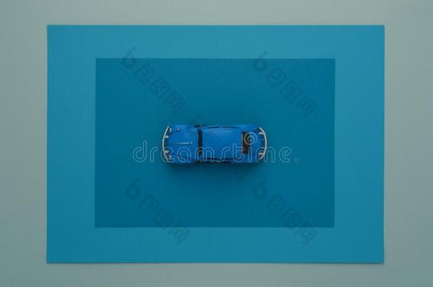 最小的蓝色汽车观念.玩具汽车向蓝色纸框架.