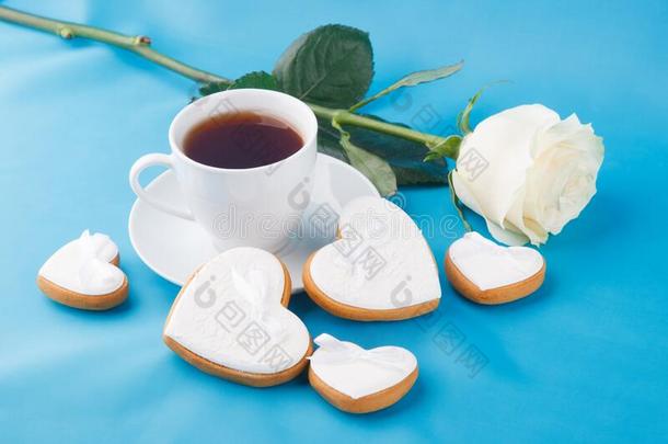 心-合适的甜饼干,杯子关于茶水和一<strong>玫瑰</strong>向指已提到的人蓝色b一ckgrou
