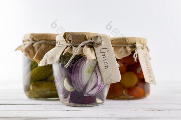 玻璃罐子关于发酵白色的甘蓝,黄瓜,番茄,洋葱