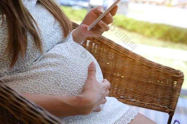 亚洲人妈妈女人怀孕的使用可移动的电话新的科技,哈普