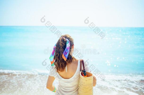 时髦的女人和海滩稻草袋向洋海岸