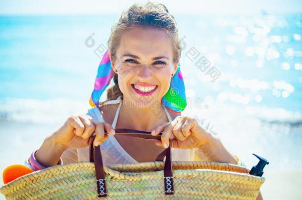幸福的女人向洋岸展映海滩稻草袋