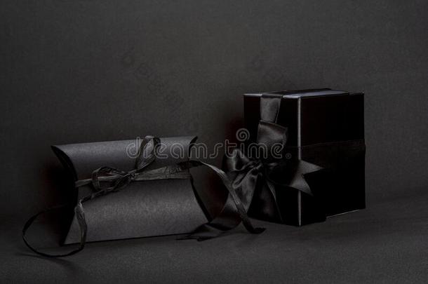 两个黑的赠品盒和黑的带弓向黑暗的背景,英语字母表的第3个字母