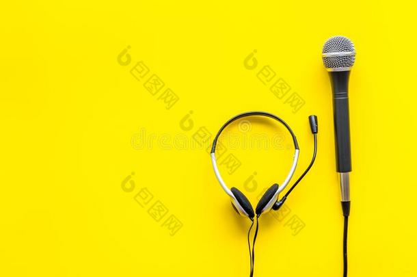 电视观念.扩音器和戴在头上的耳机或听筒向黄色的背景
