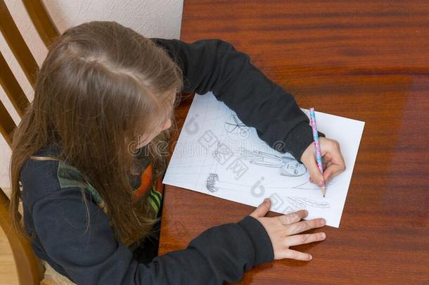 女学生绘画在一书桌.小的女孩学生学习一次