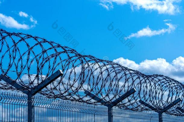 栅栏和装有倒钩的金属丝<strong>反</strong>对蓝色天和云