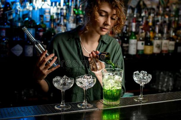 年幼的女人酒吧间销售酒精饮料的人精确的涌出绿色的喝进入中大大地glasnost开放