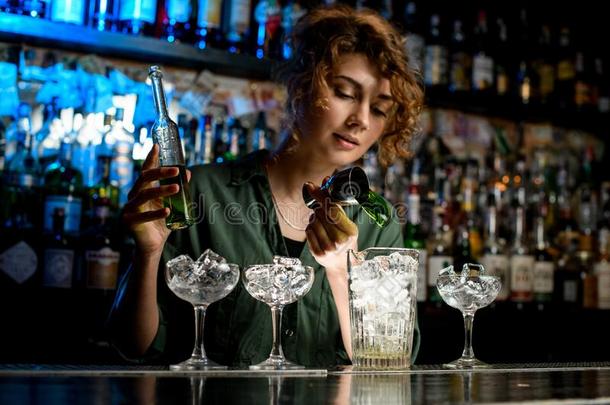 年幼的女人酒吧间销售酒精饮料的人涌出绿色的喝进入中大大地玻璃用过的是