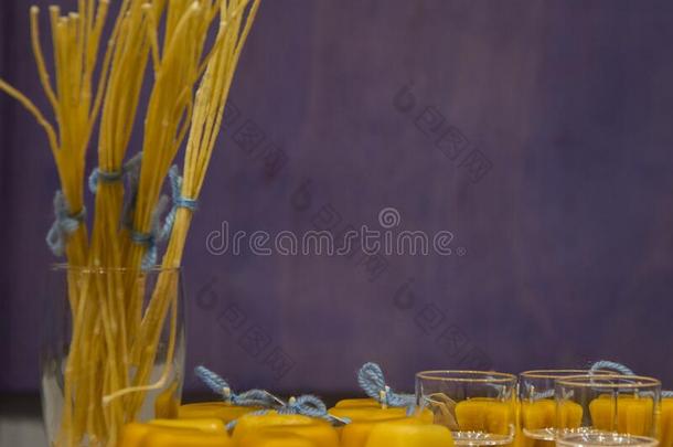 黄色的蜂<strong>蜜蜡</strong>烛和眼镜向淡紫色的背景和空间