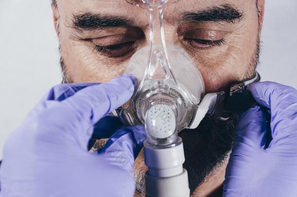 男人和呼吸的面具为辅助的呼吸