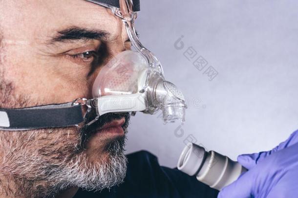 男人和呼吸的面具为辅助的呼吸