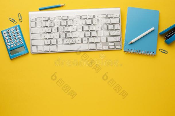 工作的黄色的表和键盘,笔记簿,计算器,铅笔