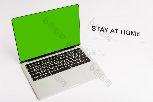 便携式电脑和绿色的屏幕在近处纸和停留在<strong>家字</strong>体