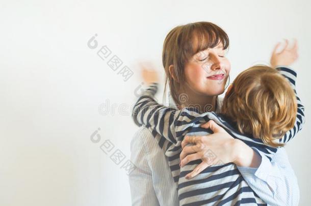 年幼的母亲和小孩热烈地拥抱.母亲一天