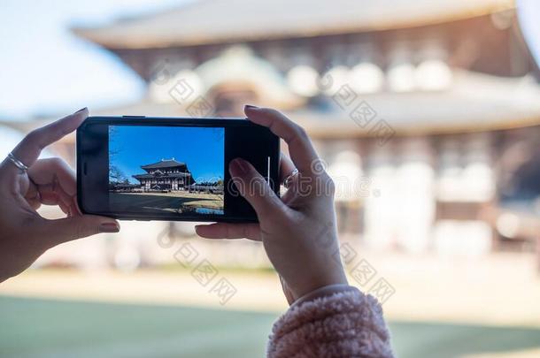 女人迷人的照片在旁边智能手机在东大吉庙,亚洲人旅行
