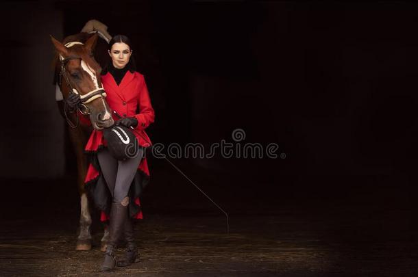 骑手赛马骑师女人采用红色的<strong>女装上</strong>衣保存马在旁边约束,令苦恼