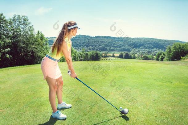 美丽的女人演奏高尔夫球向敞开的课程