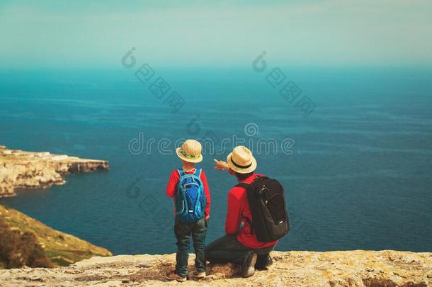 家庭旅行-父亲和儿子徒步旅行采用mounta采用s在海